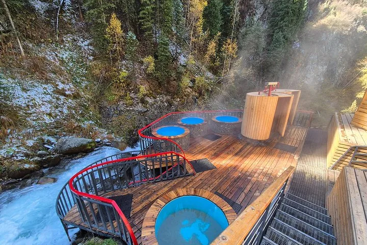 Beheizte Holz-Whirlpools im Freien auf einer Terrasse an einem Gebirgsbach.