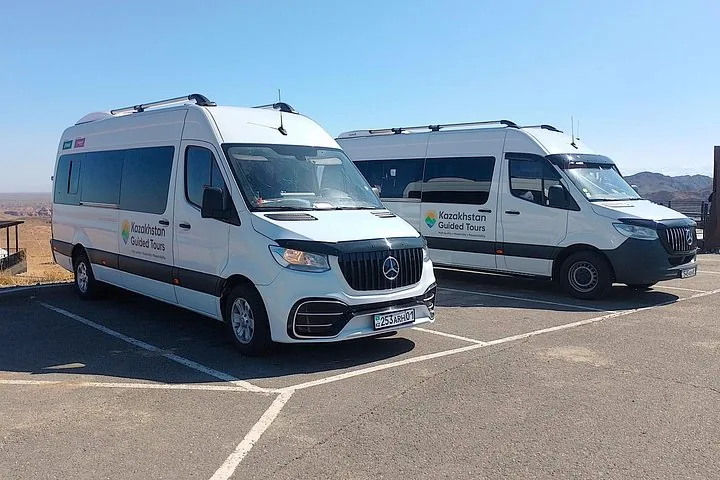 Two white Mercedes Sprinter vans with 'Kazakhstan Guided Tours' logos parked outside.